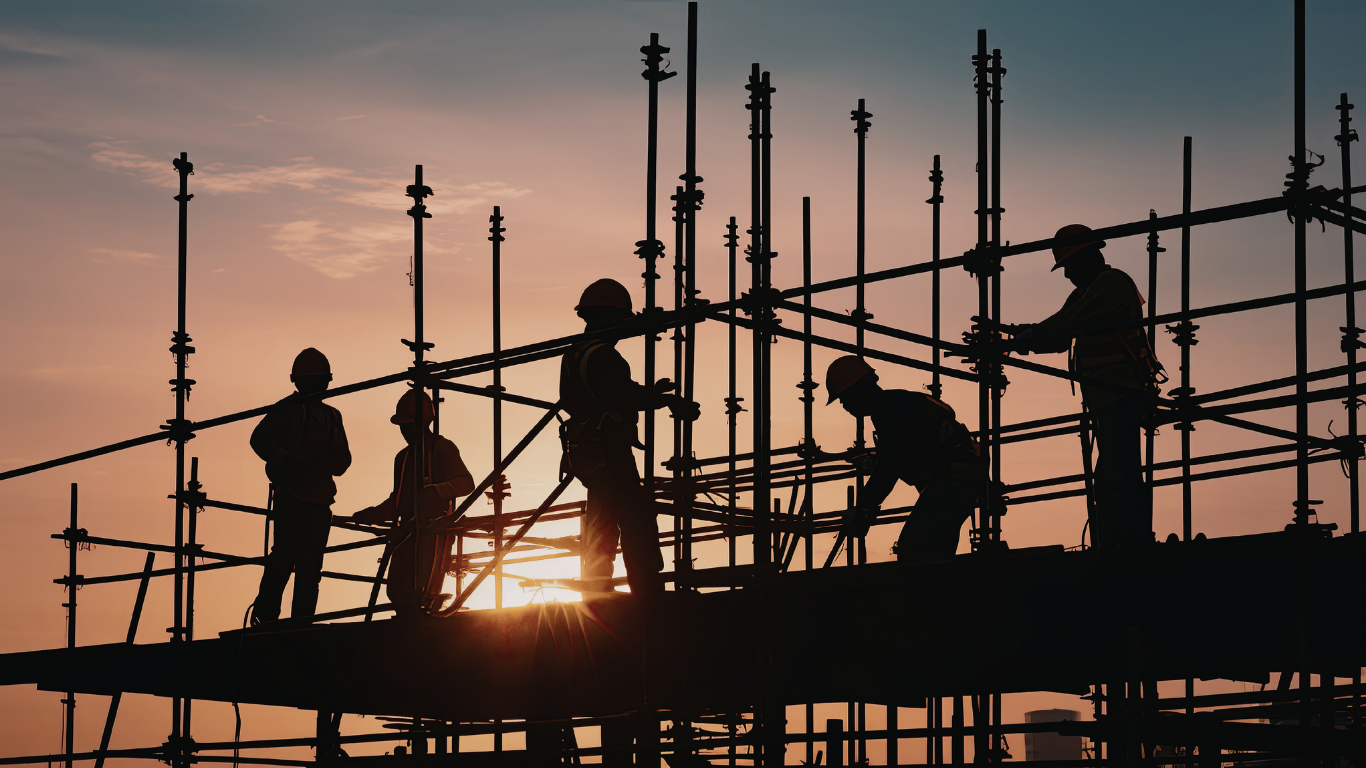 Construction cranes and scaffolding silhouette at sunset